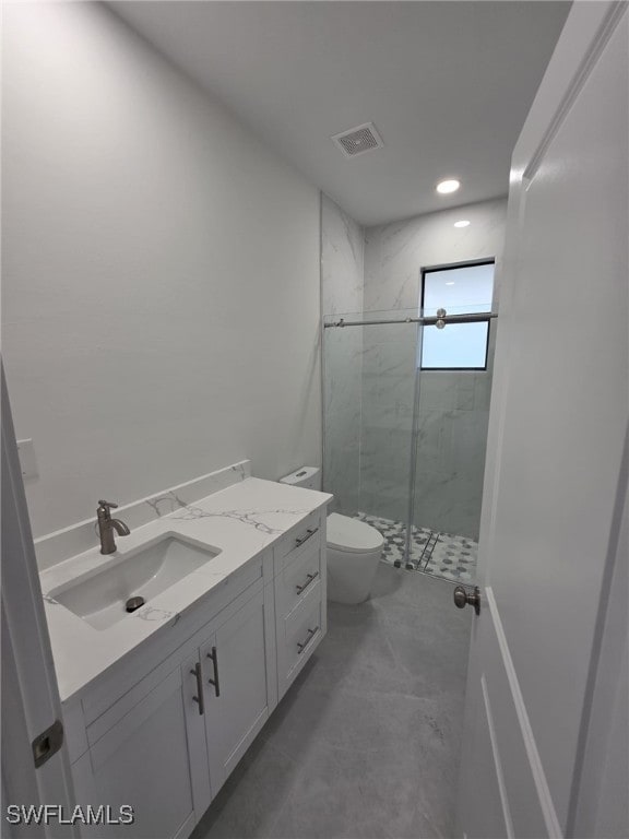 bathroom with a marble finish shower, recessed lighting, visible vents, toilet, and vanity