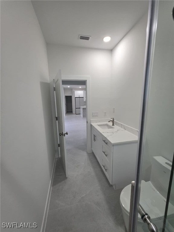 full bathroom featuring visible vents, baseboards, toilet, vanity, and a shower stall