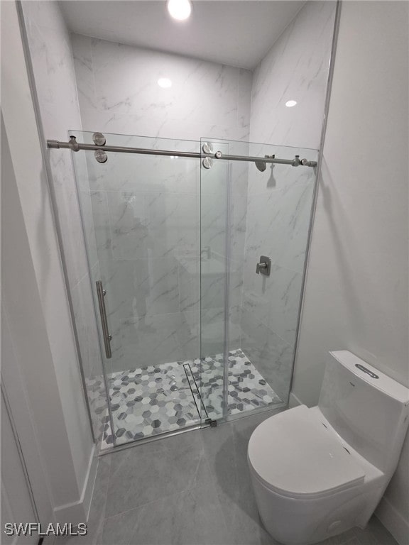 bathroom with a stall shower and toilet