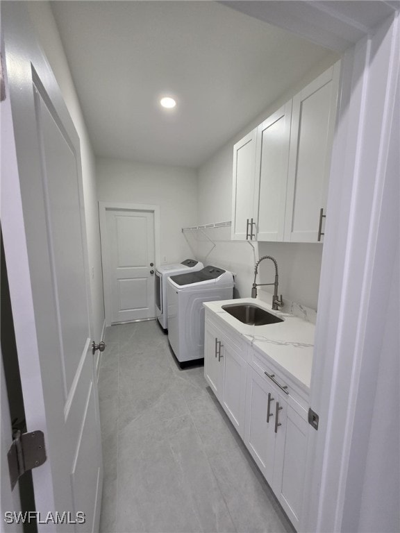 laundry room featuring cabinet space, separate washer and dryer, a sink, and recessed lighting