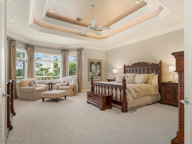 bedroom featuring ornamental molding, a tray ceiling, visible vents, and light colored carpet