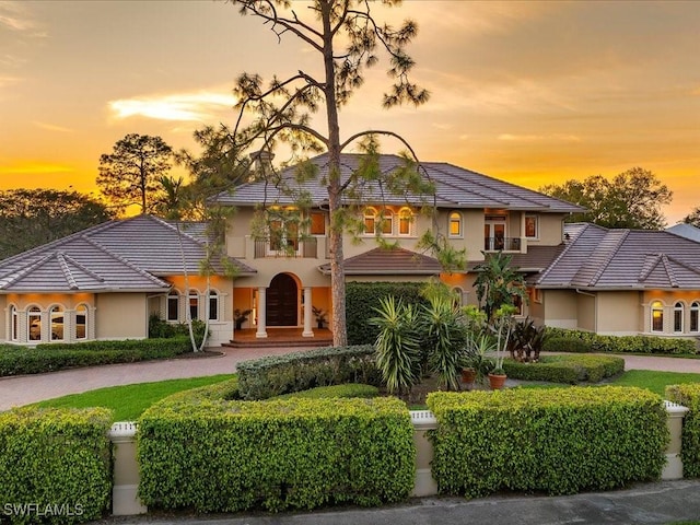 view of front facade featuring a tiled roof and stucco siding