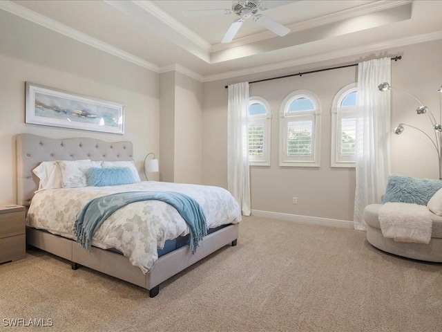 bedroom with baseboards, ornamental molding, a raised ceiling, and light colored carpet