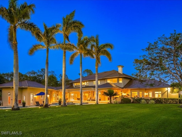 back of house with a lawn and a patio area