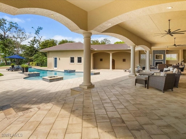 view of patio / terrace with an outdoor pool, a hot tub, and an outdoor fireplace