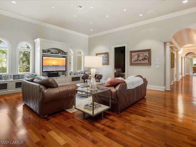 living area featuring decorative columns, visible vents, arched walkways, and dark wood-type flooring