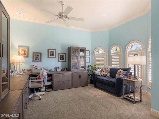 home office with baseboards, visible vents, light colored carpet, ceiling fan, and crown molding