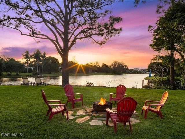 view of yard featuring a water view and an outdoor fire pit