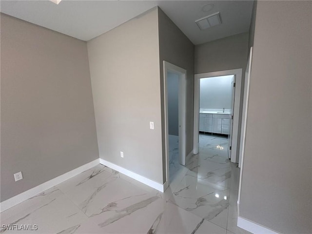 hall with marble finish floor, visible vents, and baseboards