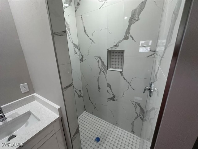 full bathroom featuring a marble finish shower and vanity