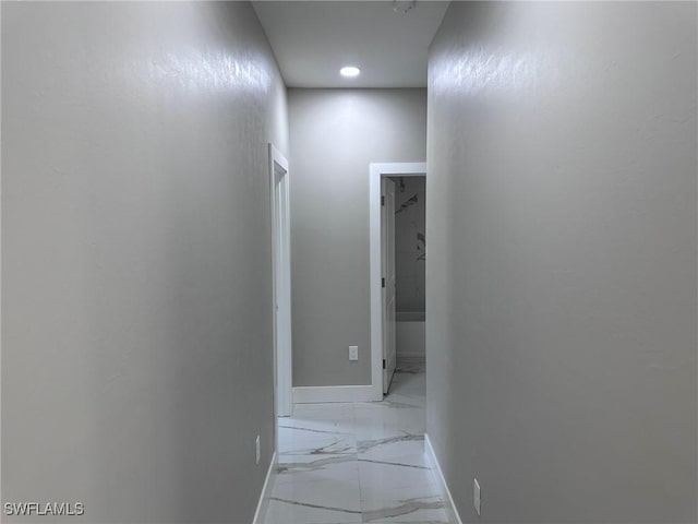 corridor featuring marble finish floor and baseboards