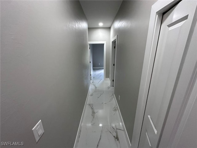 hallway with marble finish floor and baseboards