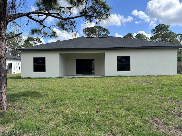 back of house featuring a yard, a patio, roof with shingles, and stucco siding