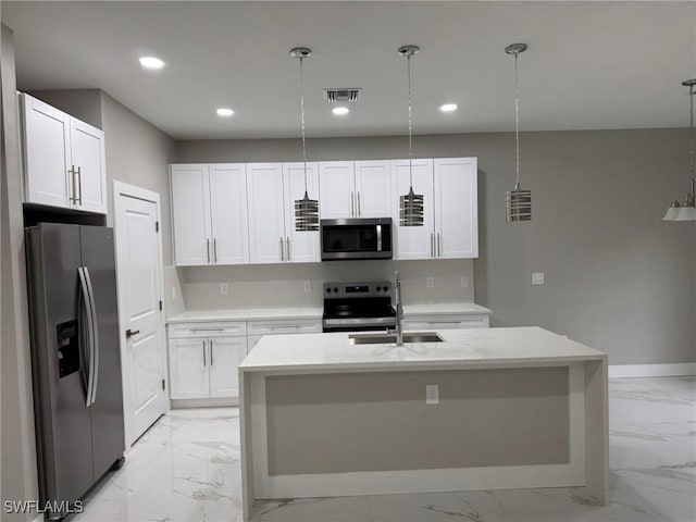 kitchen featuring appliances with stainless steel finishes, a sink, decorative light fixtures, and white cabinetry