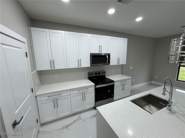 kitchen featuring stainless steel appliances, marble finish floor, white cabinets, and a sink