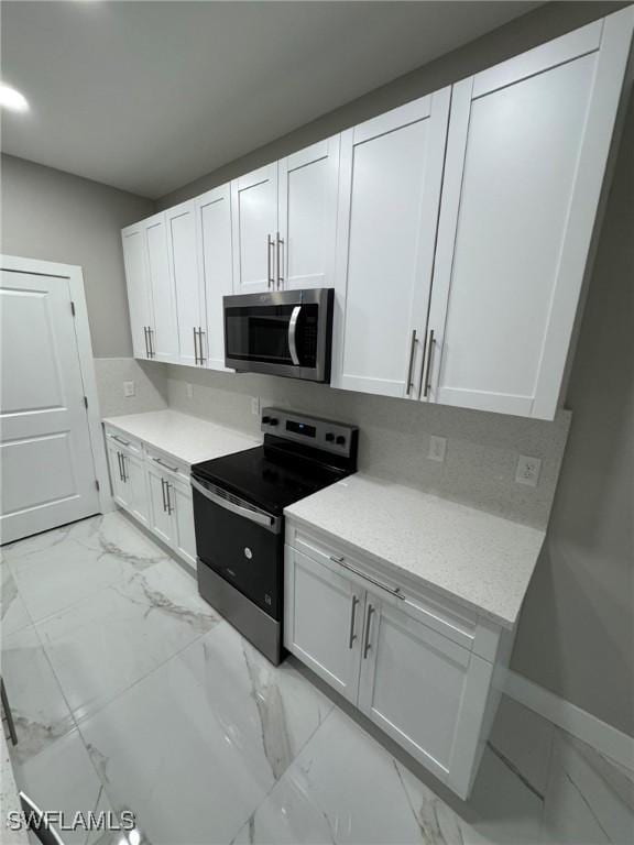 kitchen with white cabinetry, stainless steel appliances, and light countertops