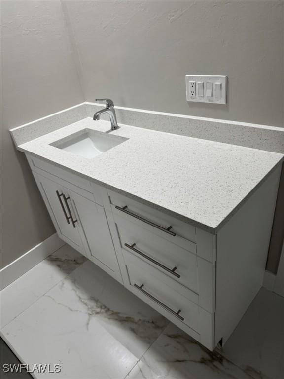 bathroom featuring marble finish floor and vanity