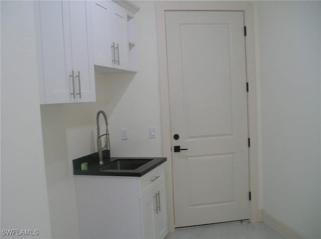 interior space with marble finish floor, a sink, and baseboards