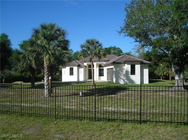 view of front of property with fence private yard, a front yard, and stucco siding