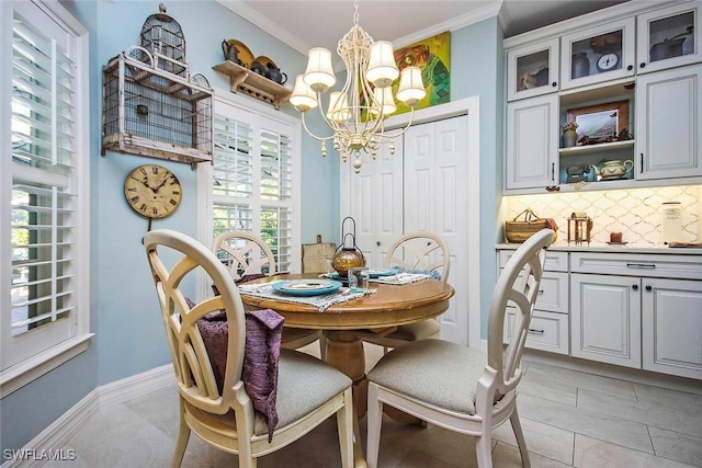 dining area featuring a chandelier, baseboards, and crown molding