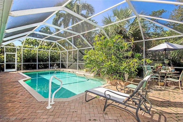 pool with glass enclosure and a patio area