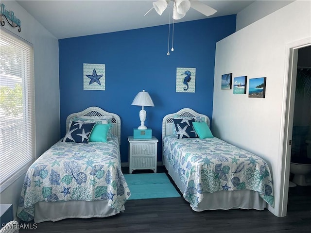 bedroom with a ceiling fan, lofted ceiling, and wood finished floors