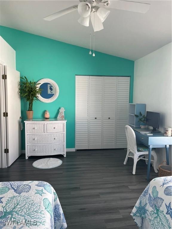 bedroom with baseboards, lofted ceiling, ceiling fan, wood finished floors, and a closet