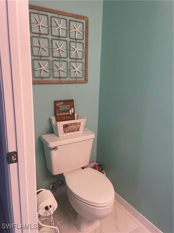 bathroom with baseboards and toilet