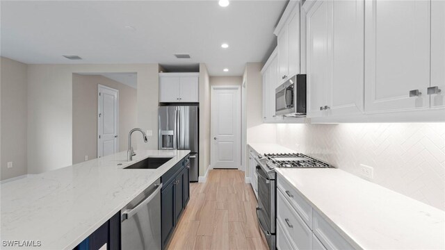 4568 Centaurus Cir, Naples, FL 34120 - kitchen with appliances with stainless steel finishes, a sink, white cabinetry, recessed lighting, and decorative backsplash