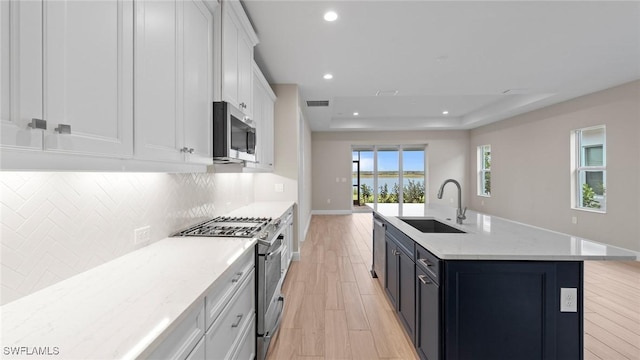 4568 Centaurus Cir, Naples, FL 34120 - kitchen with appliances with stainless steel finishes, a sink, light wood-style flooring, recessed lighting, and white cabinets