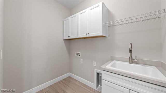4568 Centaurus Cir, Naples, FL 34120 - washroom featuring washer hookup, cabinet space, baseboards, and light wood-style flooring