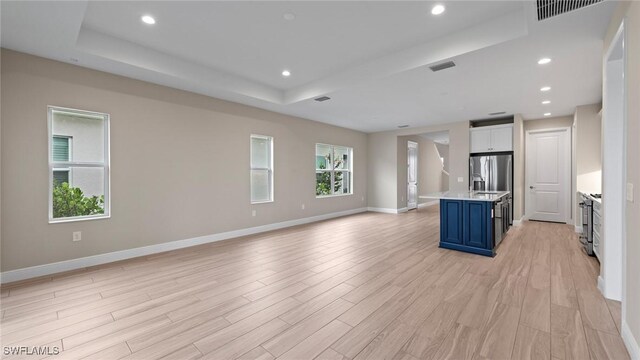 4568 Centaurus Cir, Naples, FL 34120 - unfurnished living room with a raised ceiling, light wood-type flooring, recessed lighting, and baseboards