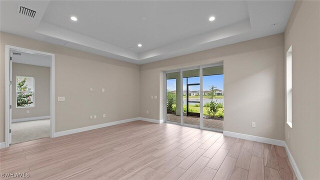 4568 Centaurus Cir, Naples, FL 34120 - unfurnished room featuring a tray ceiling, light wood-type flooring, baseboards, and recessed lighting