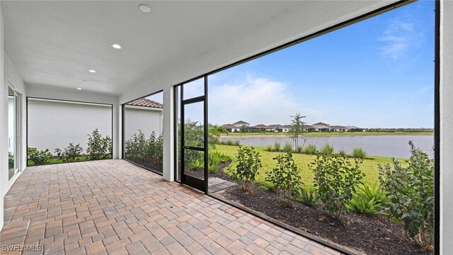 4568 Centaurus Cir, Naples, FL 34120 - unfurnished sunroom featuring a water view, brick patterned flooring, and recessed lighting