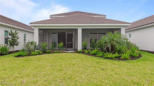 4568 Centaurus Cir, Naples, FL 34120 - rear view of house with a sunroom, a lawn, and stucco siding