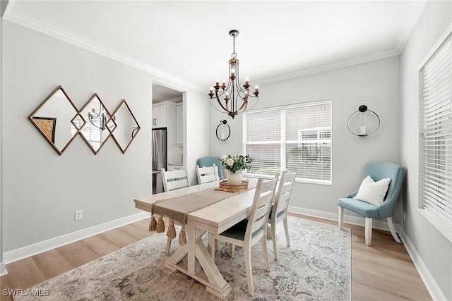 dining area with light wood-type flooring, baseboards, a chandelier, and ornamental molding