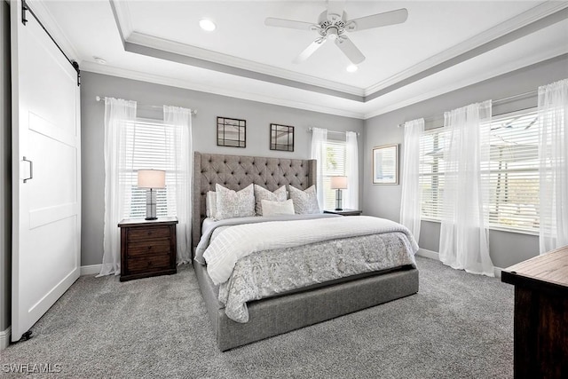 bedroom featuring a barn door, a raised ceiling, crown molding, and light colored carpet