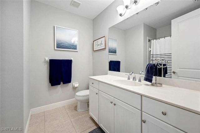 bathroom with toilet, vanity, baseboards, visible vents, and tile patterned floors