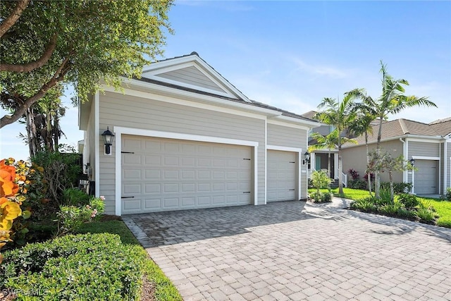 ranch-style home featuring a garage and decorative driveway