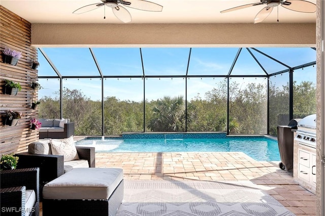 outdoor pool featuring a patio, outdoor lounge area, a ceiling fan, glass enclosure, and exterior kitchen