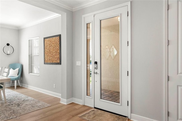 foyer featuring light wood-type flooring, crown molding, and baseboards