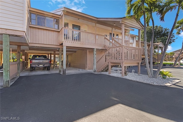 exterior space with a carport, stairway, and driveway