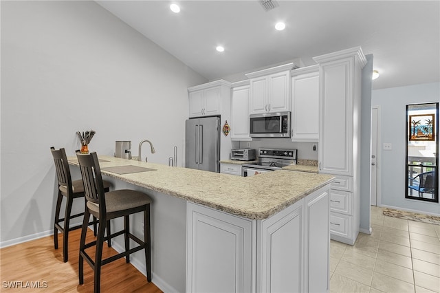 7629 Captains Harbor Dr Unit 1203, Bokeelia, FL 33922 - kitchen featuring a breakfast bar area, recessed lighting, visible vents, appliances with stainless steel finishes, and white cabinets