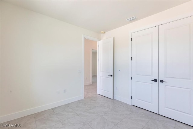 unfurnished bedroom featuring a closet, visible vents, and baseboards