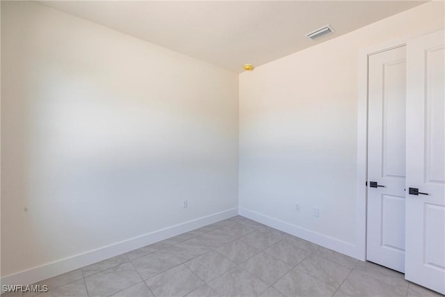 spare room with baseboards and visible vents