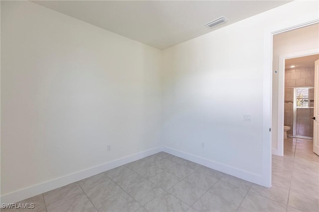 unfurnished room with light tile patterned floors, visible vents, and baseboards