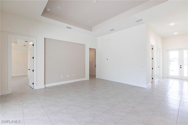 spare room with recessed lighting, visible vents, baseboards, french doors, and a raised ceiling