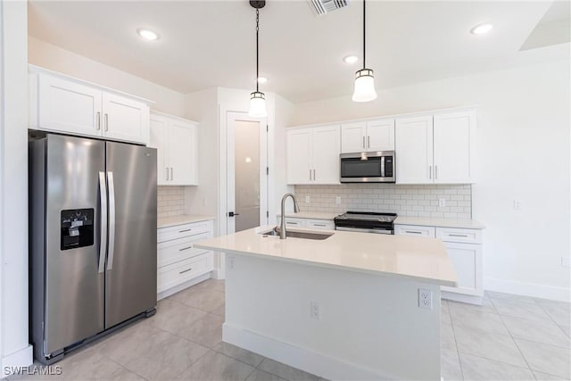 kitchen with decorative light fixtures, stainless steel appliances, light countertops, white cabinets, and a sink