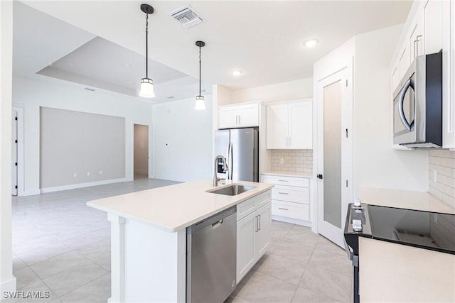 kitchen with an island with sink, white cabinetry, stainless steel appliances, and light countertops