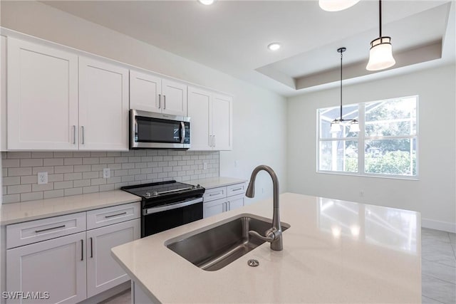 kitchen with light countertops, electric range, stainless steel microwave, and white cabinetry